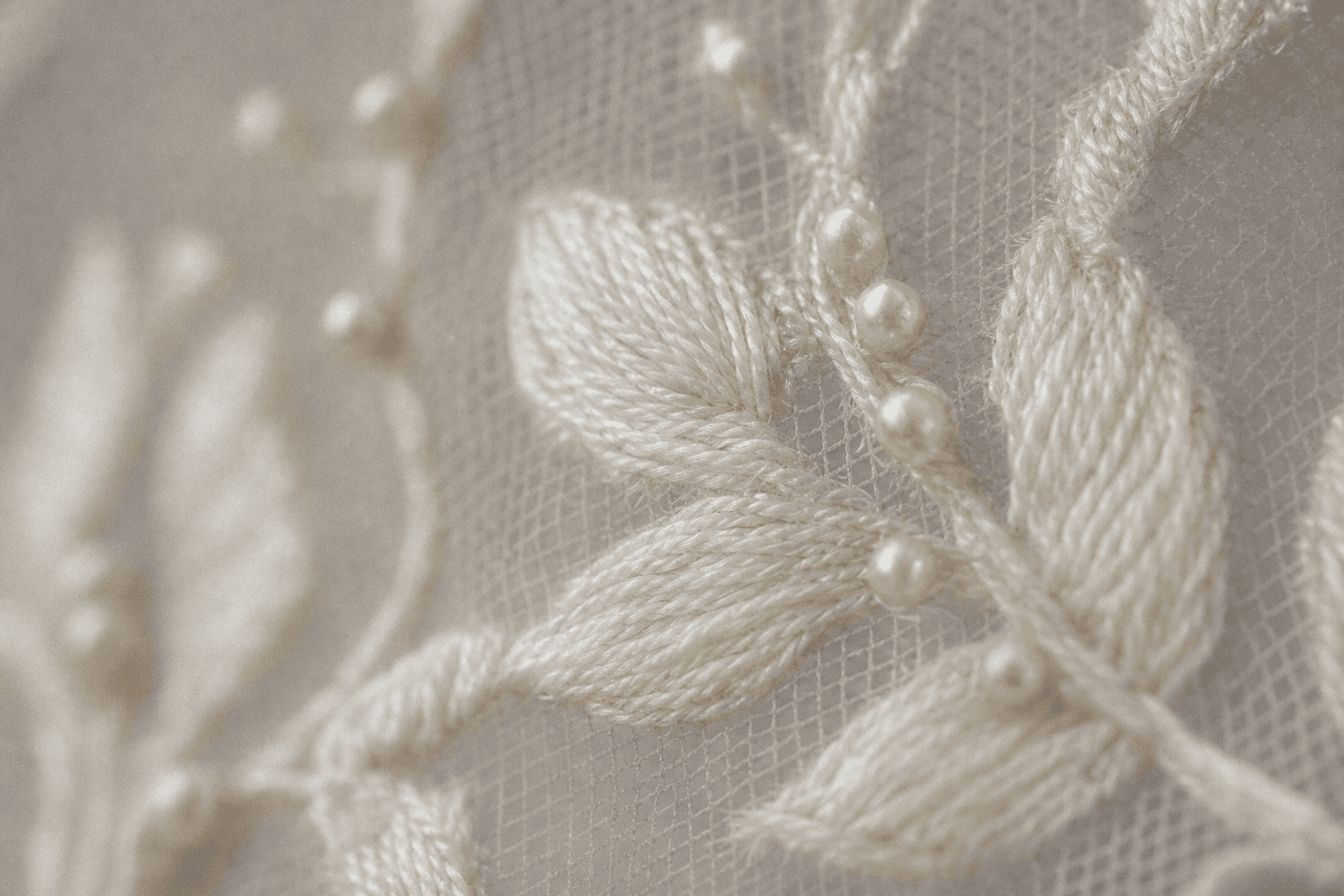 Broderie de fil ivoire et perles fines sur tulle, vue de très près